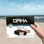 Box of Orka Vanilla Bean bars held by a hand on a beach.