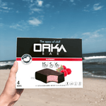 Orka Bar packaging held by a hand with a beach background