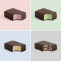 Four different chocolate-covered ice cream protein bars on a grid with pastel backgrounds.
